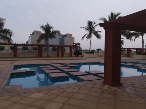 una piscina in un resort con palme di نزل المارينا - Marina Resident a King Abdullah Economic City