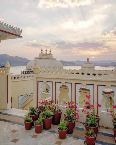 a building with potted plants in front of it at Shiv Niwas Palace by HRH Group of Hotels in Udaipur
