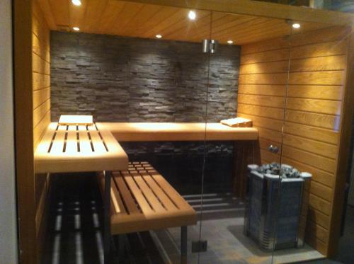 a sauna with two benches in front of a stone wall at B&B N°5 in Liège