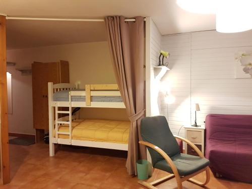 a small room with a bunk bed and a chair at Apartamentos Grifo Vacances Grizzly in Pas de la Casa