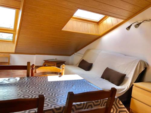 Zimmer im Dachgeschoss mit einem Bett und einem Tisch in der Unterkunft PROBER-CHAMOIX 68 in Encamp
