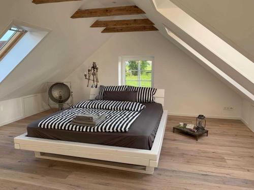 Un dormitorio con una cama grande en un ático. en Fehnhaus an der Kuhweide 45236, en Jemgum