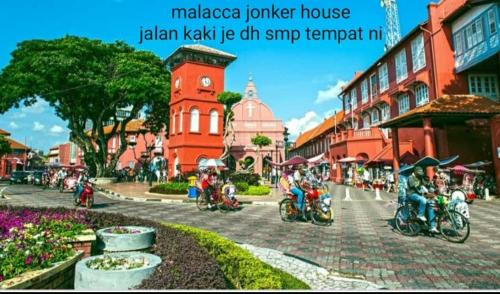 a group of people riding motorcycles down a street at Malacca Jonkerhouse in Melaka