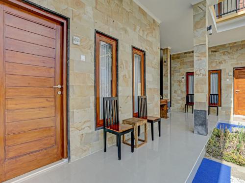 a hallway with a wooden door and some benches at The Bingin Sari Jimbaran in Jimbaran