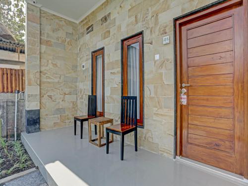 two chairs in front of a wooden door at The Bingin Sari Jimbaran in Jimbaran