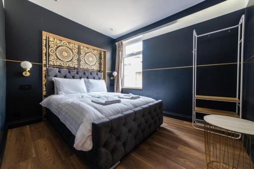 sypialnia z dużym łóżkiem z niebieskimi ścianami w obiekcie Hollywood Suite Sasco Apartments w Blackpool