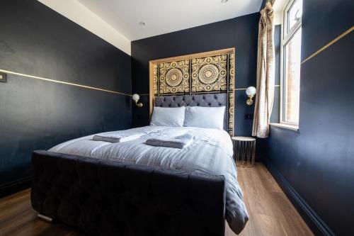 sypialnia z łóżkiem z czarną ścianą w obiekcie Hollywood Suite Sasco Apartments w Blackpool