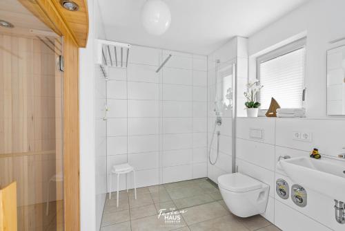 uma casa de banho branca com um WC e um lavatório em Küstenliebe em Olpenitz