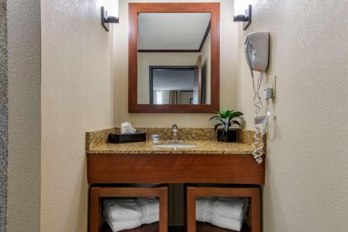 a bathroom with a sink and a mirror at Comfort Suites Manhattan in Manhattan