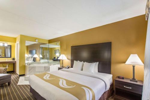 een hotelkamer met een groot bed en een badkamer bij Quality Inn London in London