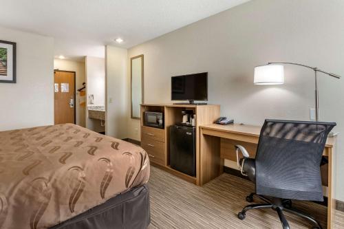 a hotel room with a bed and a desk with a computer at Quality Inn in Creston