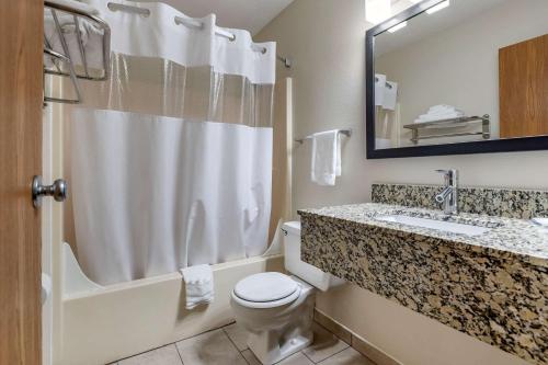 a bathroom with a toilet and a sink and a mirror at Quality Inn in Creston