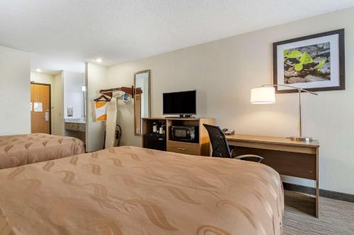 a hotel room with two beds and a desk with a tv at Quality Inn in Creston