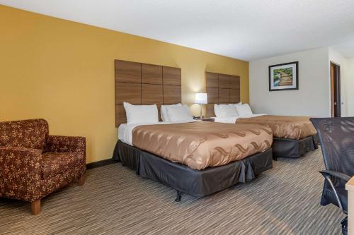 a hotel room with two beds and a chair at Quality Inn in Creston