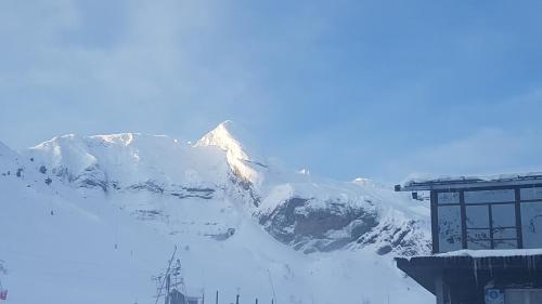 a snow covered mountain with a building in front of it at WIFI COMO EN TU CASA Canfranc Estación in Canfranc-Estación