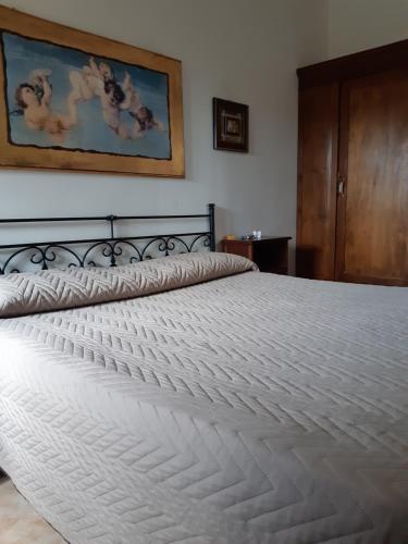 uma grande cama branca num quarto em Il Murales Montegiordano em Montegiordano