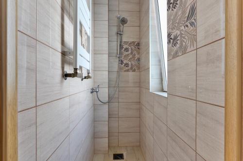 a shower with a glass door in a bathroom at Domek na Zagroniu in Istebna