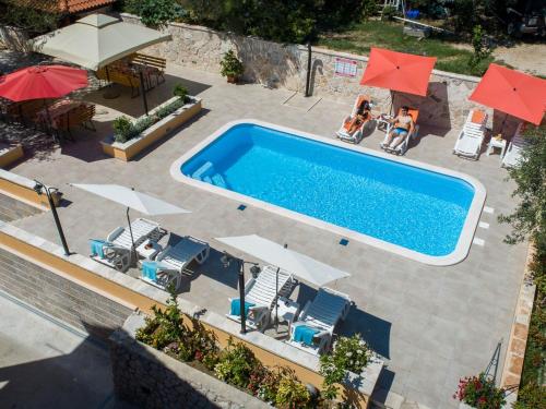 an overhead view of a swimming pool with umbrellas at Apartments Njiric in Zaton