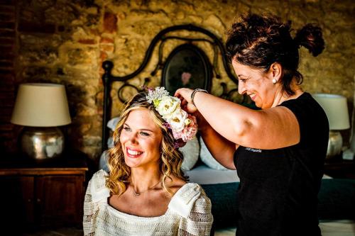 a woman helping a woman put a flower on her head at LaChiusa Tuscany in Montefollonico