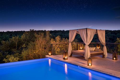 a villa with a swimming pool at night at 57 Waterberg in Welgevonden Game Reserve