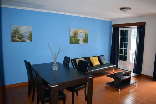 a blue living room with a table and a couch at Residência Machado in Horta