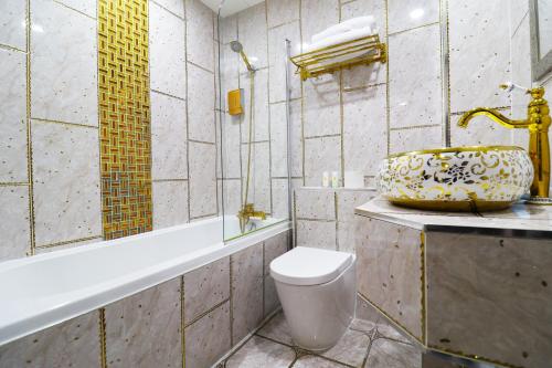 a bathroom with a toilet and a tub and a sink at Queen Stay Apartments in Sheffield