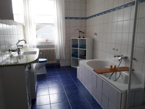 ein Badezimmer mit einer Badewanne und einem Waschbecken in der Unterkunft Ferienwohnung SimBlick in Simmerath