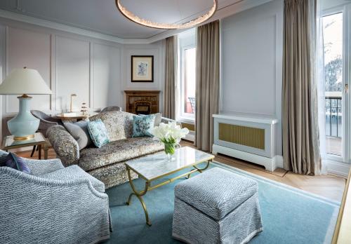 a living room with a couch and a table at Badrutt's Palace Hotel St Moritz in St. Moritz