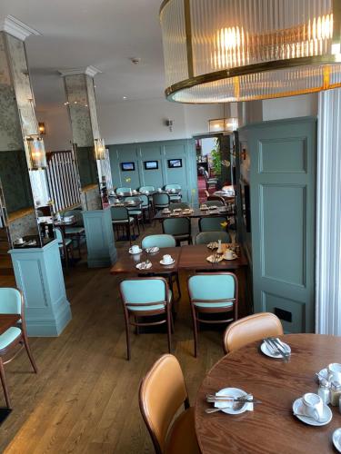 a dining room with wooden tables and chairs at The Beach Hotel in Brighton & Hove