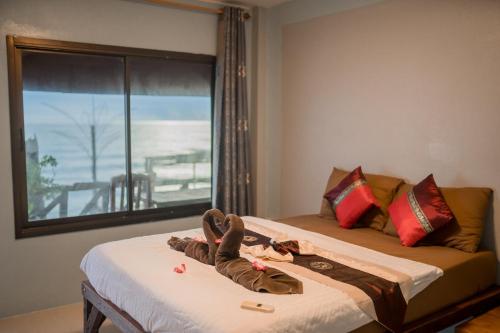 a person laying on a bed in a hotel room at Rock sand Resort in Trat