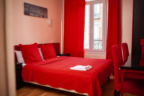 um quarto vermelho com uma cama vermelha com cortinas vermelhas em Hôtel du Parc em Choisy-le-Roi