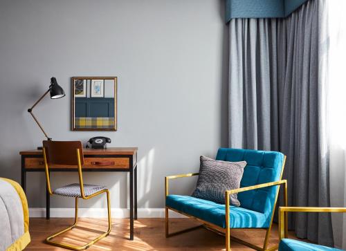 a bedroom with a desk and two chairs at Hotel Indigo - Stratford Upon Avon by IHG in Stratford-upon-Avon