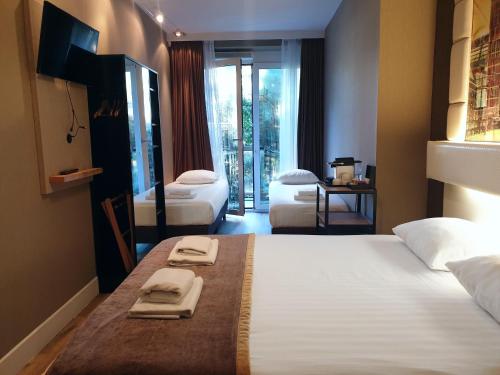 a hotel room with two beds with towels on it at Hotel Mosaic City Centre in Amsterdam
