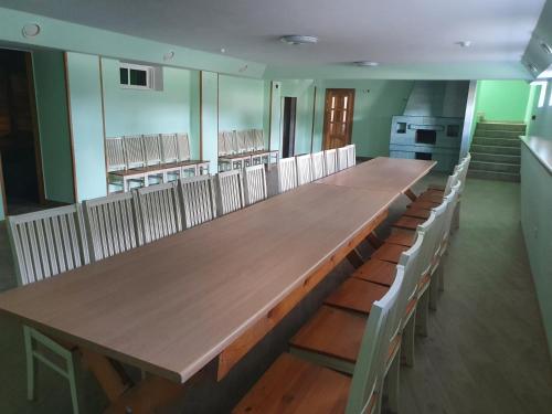 a large wooden table in a room with chairs at Pasienis in Pasvaliečiai