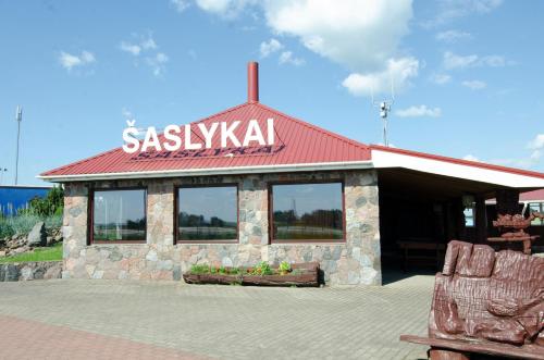 a restaurant with a sign on top of a building at Pasienis in Pasvaliečiai