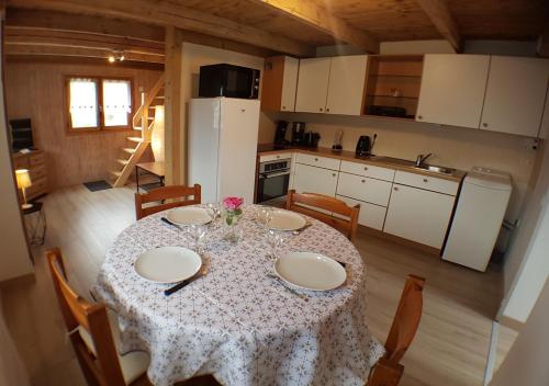 uma cozinha com uma mesa com uma toalha de mesa branca em Chalet avec terrasse et vue sur le Mt-Blanc em Sallanches