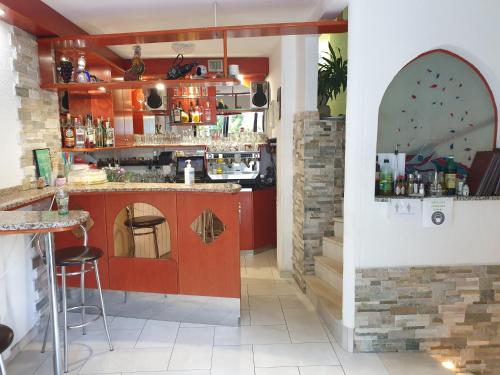 Čiginj的住宿－Gostišče TI Sobe Mici，一间酒吧,餐厅里设有红色橱柜和柜台