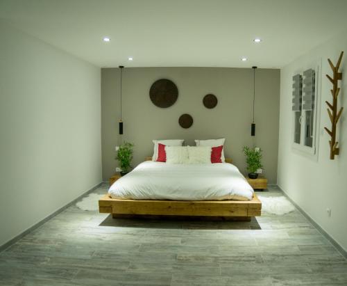 a bedroom with a bed with white sheets and red pillows at Le petit paradis in Orange