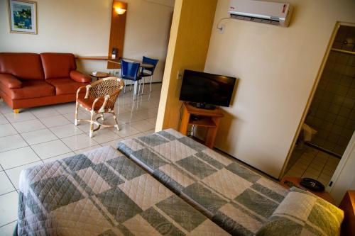 um quarto com uma cama, um sofá e uma televisão em Praia Mansa -PM - RP em Fortaleza