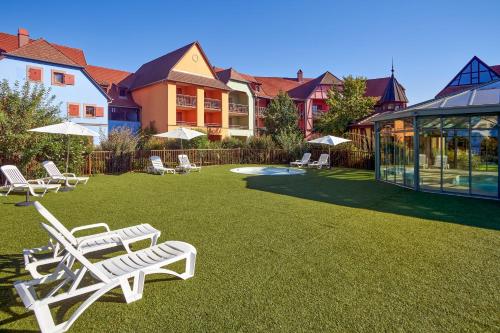 a group of lawn chairs sitting on the grass in a yard at Résidence Pierre & Vacances Le Clos d'Eguisheim in Eguisheim