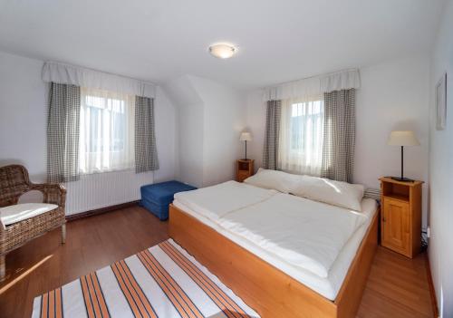 a bedroom with a large bed and two windows at MINERVA in Špindlerův Mlýn