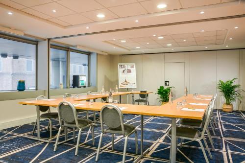 a conference room with long tables and chairs at Residence Mercure Paris La Defense Grande Arche in Nanterre
