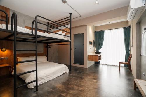 a bedroom with two bunk beds and a desk at Simple Living in Taitung City