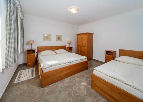 a bedroom with two beds and two night stands at MINERVA in Špindlerův Mlýn