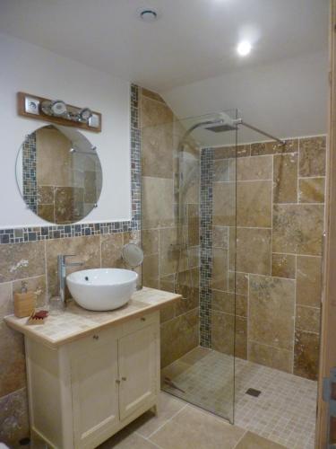 une salle de bain avec un lavabo et une douche en verre dans l'établissement Le Moulin de Cors, à Oulches