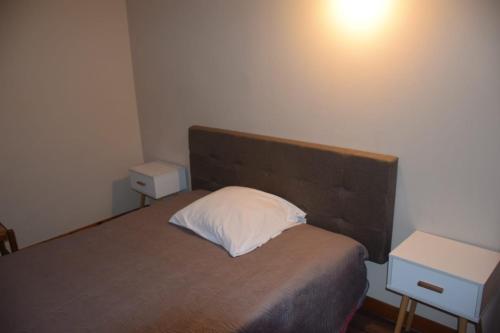 a bedroom with a bed with a white pillow on it at Hôtel Résidence Champerret in Levallois-Perret