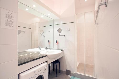 biała łazienka z umywalką i prysznicem w obiekcie GAL Apartments Vienna w Wiedniu