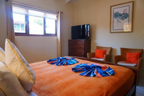 a bedroom with a large bed with orange sheets at Cariñas Studio Apartments in Palm-Eagle Beach