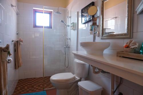 a bathroom with a toilet and a sink and a shower at Cariñas Studio Apartments in Palm-Eagle Beach