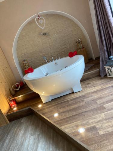 a bathroom with a white tub in front of a mirror at MANOIR AUX trois charmes in Ronchamp